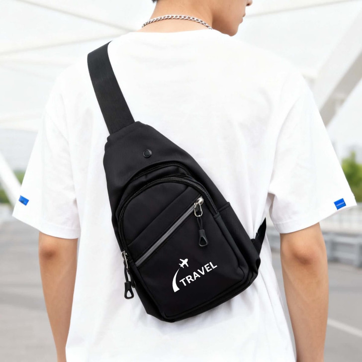 A black sling bag with a logo, featuring multiple zippered compartments, worn across the back of a person.