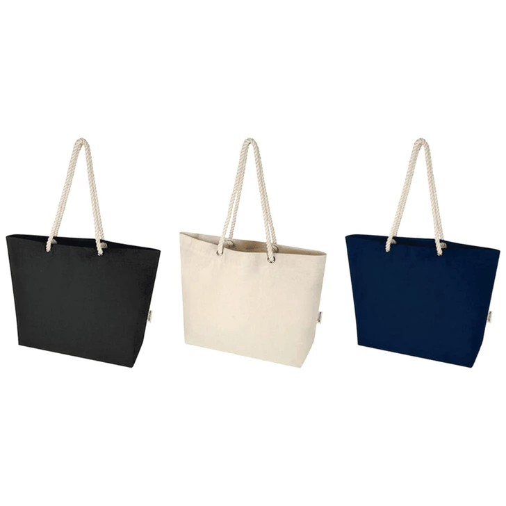 A tote bag in black, cream, and navy, featuring rope handles and a simple design. It has a logo on one side.