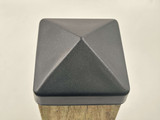 Top view of a 4x4 black steel post cap on a 3.5" wood post.