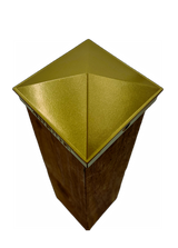 Top view of a gold fence post cap on a wood post