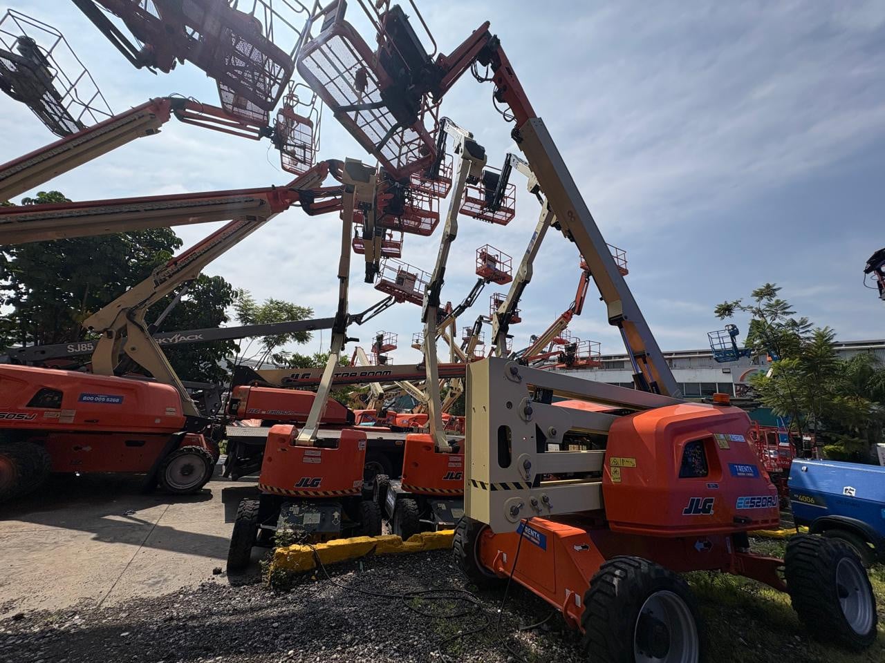 Plataforma articulada eléctrica JLG EC520AJ usada estacionada en patio de maquinaria