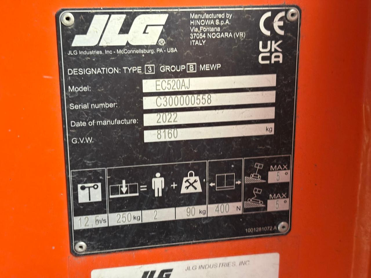 Placa de especificaciones técnicas y número de serie del fabricante en el chasis de un equipo JLG.
