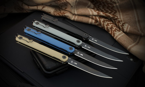 Spartan-Nemec Folder knives shown in four GFN handle colors—Grey, Black, Blue, and Tan—arranged side by side with blades open, showcasing black PVD CPM S35VN blades, deep-carry wire clips, and lightweight, ergonomic handles