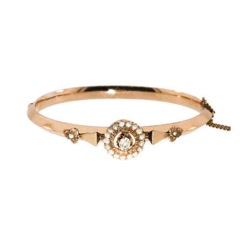 An Antique Gold Bangle with a Old European Cut Diamond and Seed Pearl Flowers