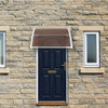 100 x 80 Household Application Door and Window Awnings, brown door canopy, installed above a black door and windows on a stone wall.
