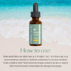 Sea Moss Liquid Drops bottle, 10,000 mg Organic Irish Sea Moss, brown glass bottle with green label and black dropper, on beach background.