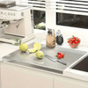 Stainless steel cutting board with lip on white kitchen counter, accompanied by sliced apples, strawberries, and knife on Honesty House kitchen board.