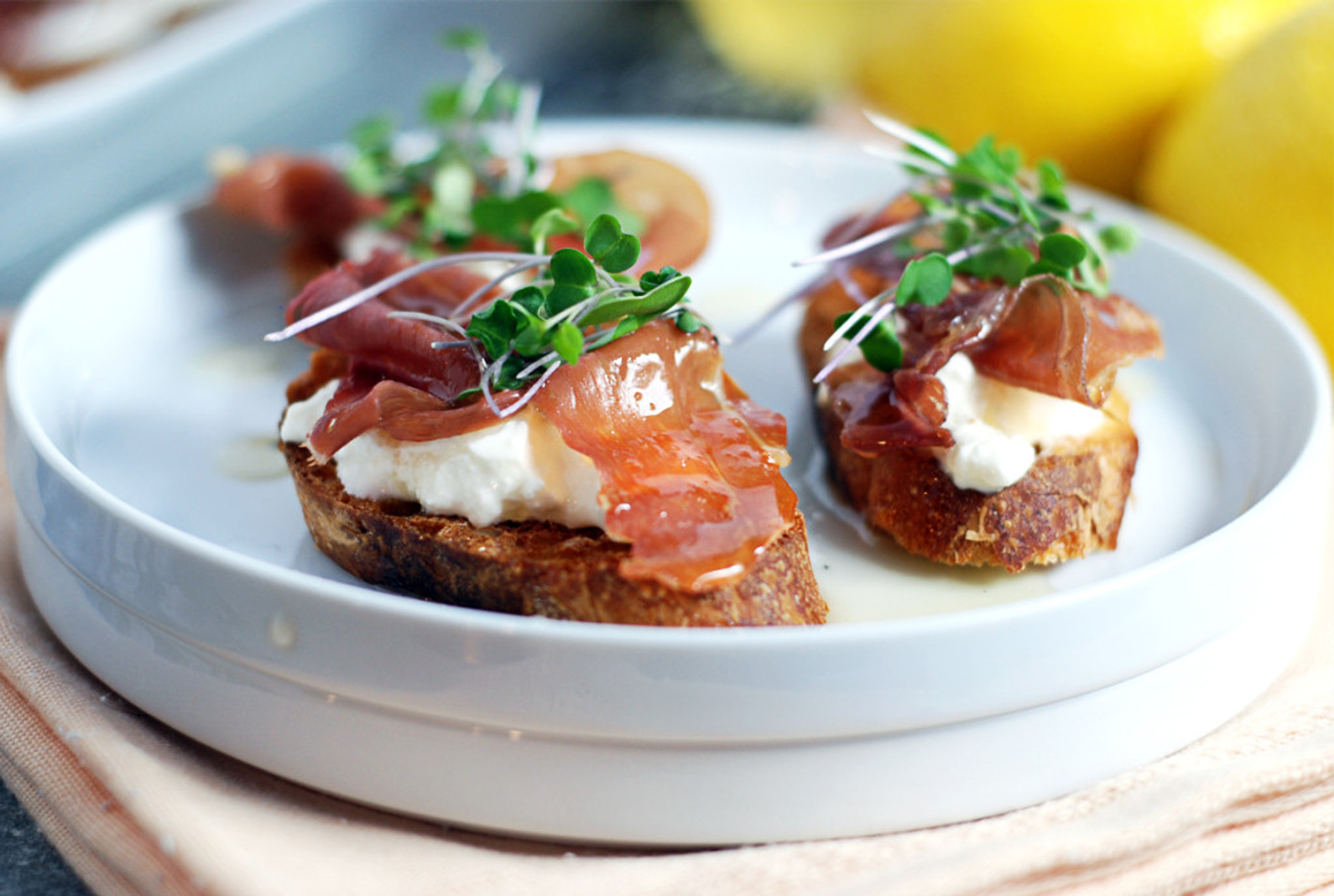 PROSCIUTTO CROSTINI WITH BURRATA AND LEMON HONEY DRIZZLE