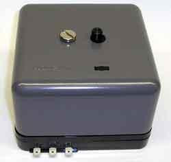 Honeywell product, a gray control unit with a gold-colored dial, black knob, and multiple connection ports on the bottom.