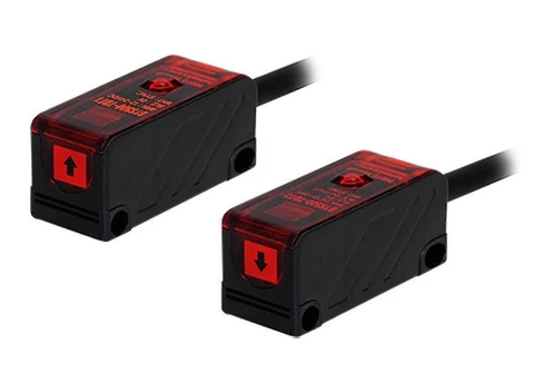 Autonics BYS500-TDT1.2, photo of two compact optical sensors with black and red housings, featuring directional arrow indicators on the front, used for industrial automation and sensing applications.