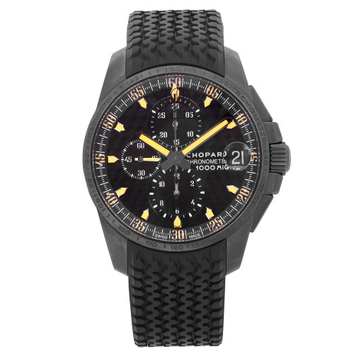 This is an image of a pre-owned Chopard Venezuela Limited Edition men's wristwatch, viewed frontally at a straight angle. The watch boasts a textured black strap and a detailed black dial with luminous hands, a date indicator at the 3 o'clock position, and a small seconds subdial. There are some dings, scuffs, and scratches on the bezel, along with micro scratches on the crystal. The watch is positioned centrally and is captured at a close distance, highlighting its intricate design and features. 