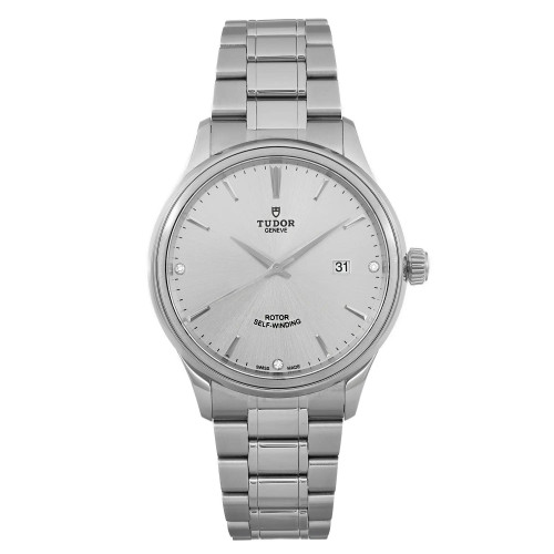 An image of a men's TUDOR Style 41mm wristwatch, shown from a front-facing angle. The watch features a silver diamond dial with a date indicator on the right side. It is unworn and has a stainless steel bracelet. The photograph is taken at a close distance to clearly display the watch's details, including its branding and self-winding feature.