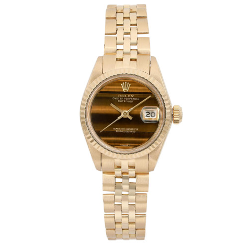 An image of a pre-owned women's luxury wristwatch viewed from a front full-frontal angle. The watch features a round yellow gold case and band. The dial is brown with a linen pattern and has stick indexes, complemented by a gold bezel. The watch includes a date indicator on the right side of the dial.