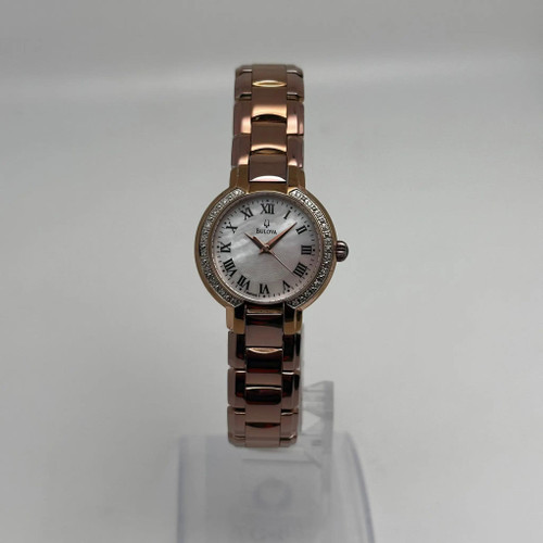 An image of a Wristwatch by Bulova . This Pre Owned item is designed for Women, featuring a Casual style. It has a Quartz movement and an Analog display with a White dial color. The indices include 12-Hour Dial,Roman Numerals. The band is made of Rose Gold Plated,Stainless Steel and the case is made of Rose Gold Plated,Stainless Steel. The watch has a Round shape with a case size of 27 mm and a case thickness of 7 mm.