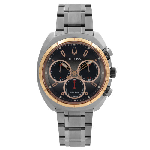 An image of a pre-owned Bulova men's wristwatch in excellent condition, presented in a full frontal view. The watch features a round stainless steel case with a rose gold-tone bezel and a gray dial. It has non-numeric hour marks and stick indexes, along with luminous hands. There are three subdials for chronograph functions and a small seconds subdial, all positioned on the dial. The stainless steel band is attached at both sides of the case, providing a casual yet dress/formal style. The watch is photographed from the front at a close distance, allowing clear visibility of its features and the "Bulova" brand name on the dial.