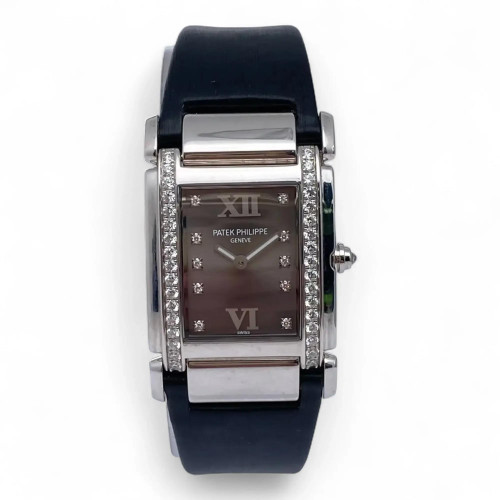 An image of a pre-owned Patek Philippe Twenty-4 18K White Gold Diamond Gray Dial Watch 4920G women's wristwatch taken from a straight-on angle, showcasing the rectangular face. The watch features a gray dial with Roman numerals and diamond hour markers, framed by a series of diamonds along the bezel. The timepiece has a black strap and is positioned centrally against a plain white background, capturing the intricate details from a close distance.
