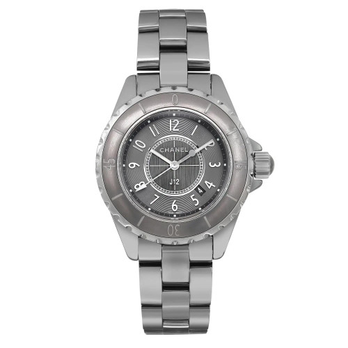 An image of a pre-owned CHANEL casual style wristwatch with a full frontal view. The watch has a round gray dial and bezel, with Arabic numerals and 12-hour dial indices, a date indicator at the 4:30 position, and luminous hands. It features a ceramic band and case, both exhibiting light scratches and signs of wear, indicative of its good condition class. The watch is photographed up-close, centered, and straight on, providing a clear view of its details. The watch shows light scratches on the band and case.