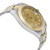 An image of a pre-owned Rolex men's wristwatch in a luxury style, captured from a side profile view opposite the crown. The watch, positioned at a slight angle and shown at close distance, features a round shape with a champagne-colored dial and a gold bezel. The band is made of stainless steel and yellow gold. The watch shows minor signs of wear.