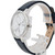 An image of a women's Skagen wristwatch displayed at a slight angle, focusing on the side and front. The watch features a marbled white face with minimalist design elements and a silver-toned case. It is positioned upright on a clear stand, showcasing a dark leather strap. The distance of the shot provides a detailed view of the watch's face and band.