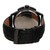An image of a pre-owned men's GUESS wristwatch, shown from the back at a close distance and slightly angled upward. The focus is on the stainless steel case back, with visible engravings, and the attached black leather strap featuring a buckle clasp. The watch includes features like a chronograph, date indicator, and luminous hands.