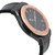An image of a pre-owned men's Hublot wristwatch, viewed from a side angle. The watch features a black strap and a rose gold bezel with visible screws. The face of the watch is dark with rose gold hour markers and hands, and includes a date indicator. The angle shows the watch at a slight tilt, highlighting the thickness of the case and the texture of the strap, captured from a close distance.