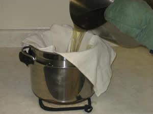 Pour the liquid tallow through a cloth-lined colander into a pot.