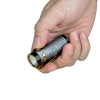 Olight Baton 4 held in hand, showing compact size and ergonomic design