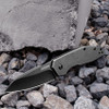 Kershaw Gravel 2065 assisted knife displayed open on gravel surface, highlighting the reverse tanto blade shape and compact profile.
