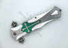 Closed view of silver and green templar-inspired folding knife with cross-style assisted opening tabs