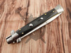 Closed Frank Beltrame stiletto with genuine dark buffalo horn handle and polished steel bolsters