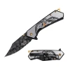 Dark Side Blades Gold spring assisted knife featuring a black clip point blade with embossed skull graphics and a stainless steel handle engraved with a hooded skull design.