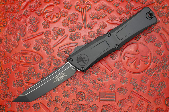 Microtech Combat Troodon Gen III OTF Knife open, showing black tanto M390 blade and anodized black handle. Microtech Combat Troodon Gen III OTF Knife open, showing black tanto M390 blade and anodized black handle.