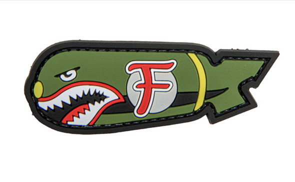 OD green PVC morale patch shaped like a bomb with shark teeth and a red “F” marking, featuring hook-and-loop backing.