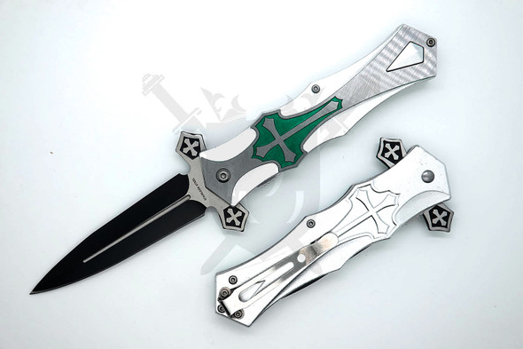 Open medieval crusader-style folding knife with black spear point blade and silver aluminum handle featuring emerald green cross artwork
