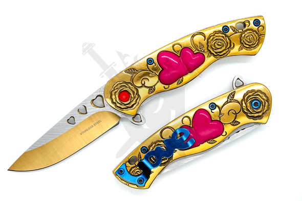 Gold spring assisted pocket knife with pink heart inlays and engraved floral handle opened beside closed view