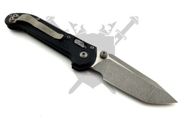 Angled view of the Microtech LUDT RAM-LOK highlighting the textured black G-10 handle, ambidextrous thumb studs, and apocalyptic tanto blade.