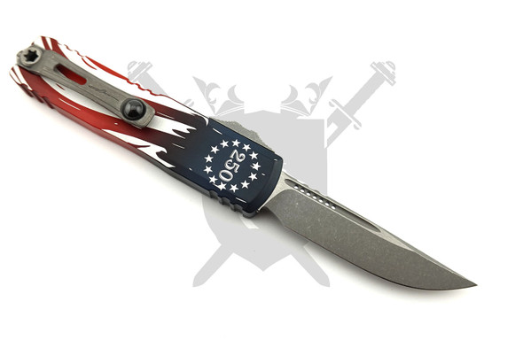 Reverse side of the Microtech Signature Series UTX-85 Gen IV showing the apocalyptic drop point blade, titanium pocket clip, and engraved 250th Anniversary handle artwork.
