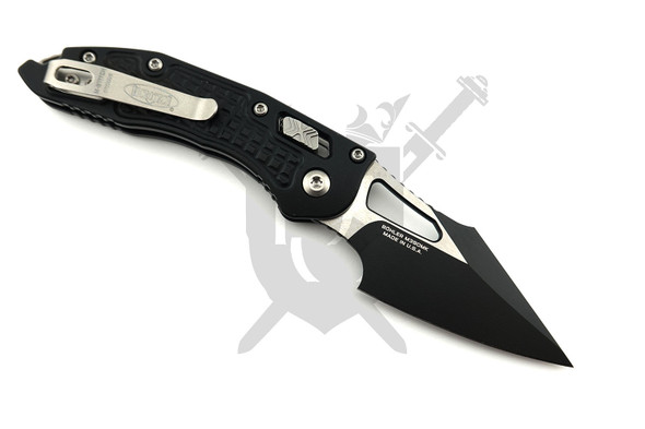 Reverse side of the Microtech M-Stitch RAM-LOK featuring the black spear point M390MK blade, deep-carry stainless pocket clip, and Black Frag aluminum handle.