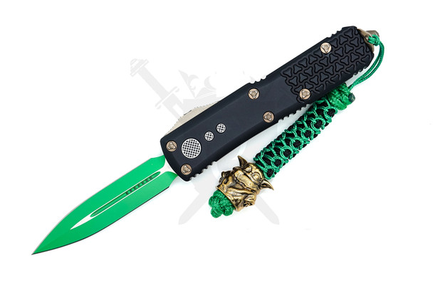 Microtech UTX-85 232-1JM Jedi Master knife open with green double-edge dagger blade and black tri-grip handle featuring brass Yoda bead on green paracord lanyard.