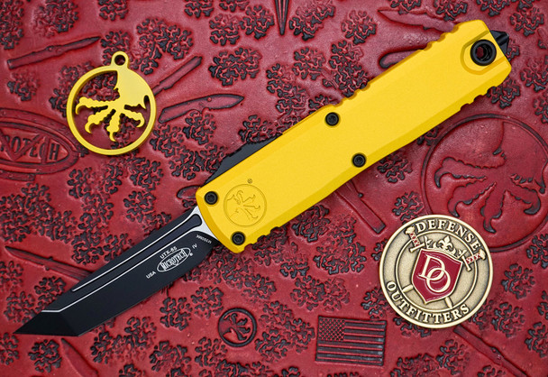 Microtech UTX-85 Gen IV OTF knife open showing black tanto blade and yellow handle front view