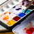 A lifestyle image of a Golden QoR Watercolor 6-Color Urban Sketch Half Pan Set in use.