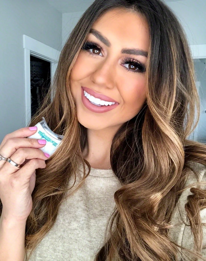 Customer smiling while holding the BleachBright NightBright LED whitening light