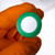 A gloved hand holding a SeptaSecure cap for a 15 mL centrifuge tube, featuring an uncut silicone septa. This cap is designed for precise and sterile sample management, and it is ideal for use in high-precision laboratory settings where contamination prevention and sample preservation is critical.