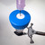 A syringe needle piercing through the white septum of a blue SeptaSecure cap on a 50 mL Type-F tube, which is secured in a metal clamp. This demonstration highlights the precision and convenience offered by the SeptaSecure design, ensuring contamination-free access to the contents of the Type-F centrifuge tube.