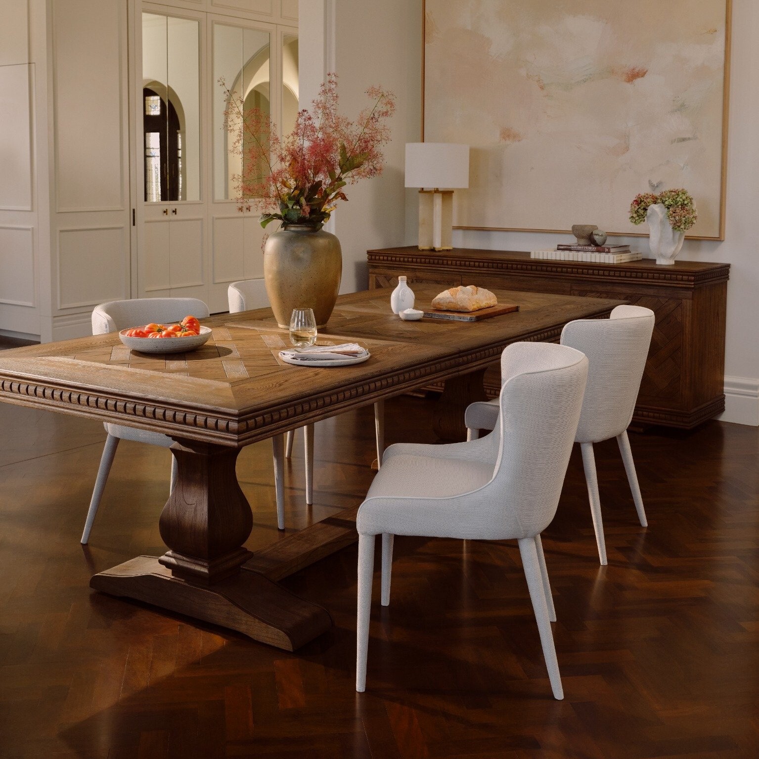 A parquetry timber dining table laid with various plates and bowls