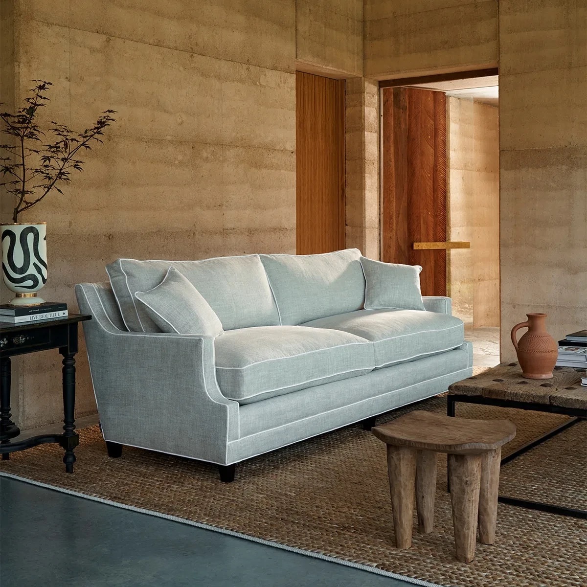 Ashley sofa in soft blue upholstery, styled in a warm timber-panelled living room.