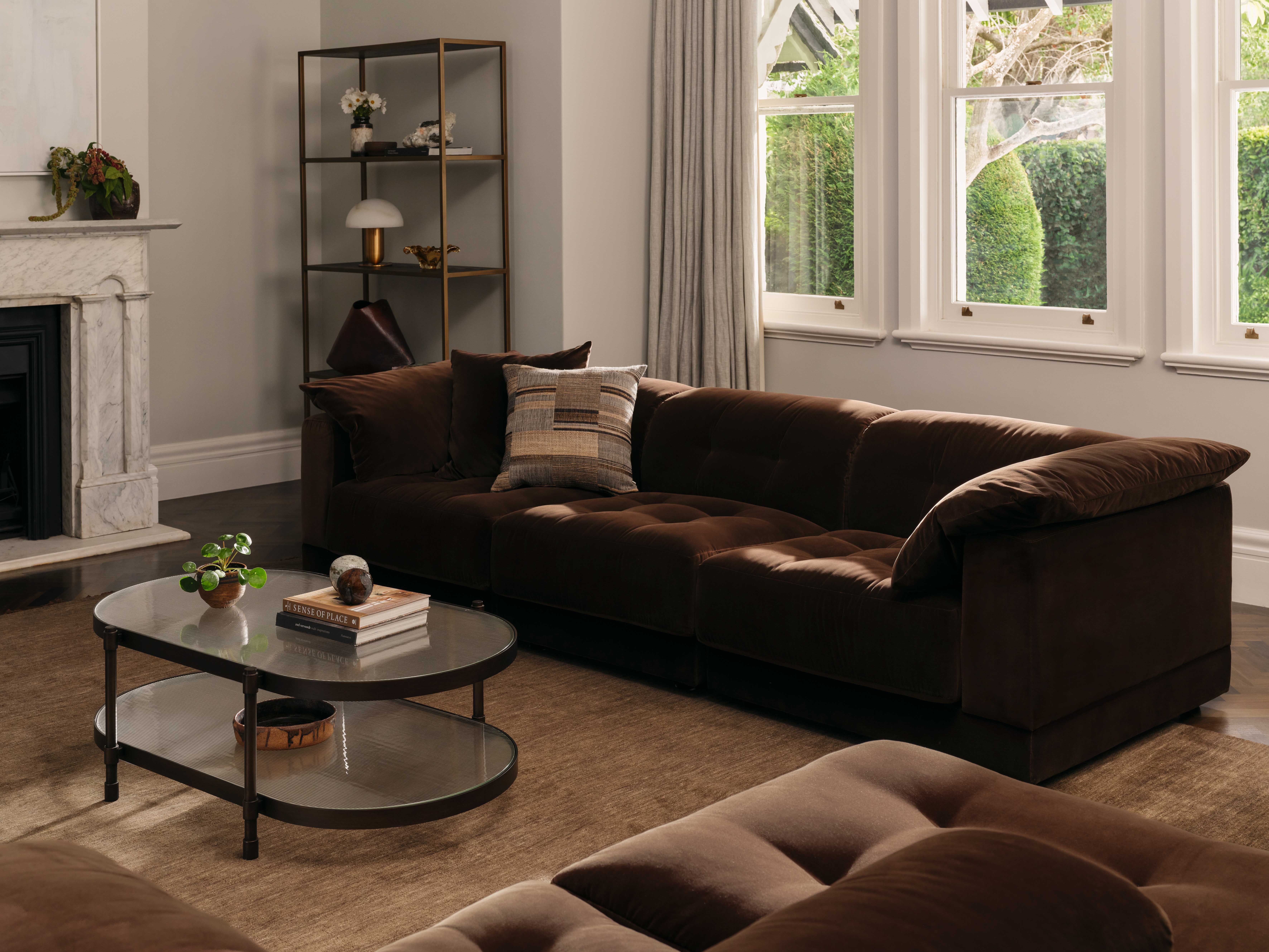 Coco Republic Malone Modular Sofa in rich chocolate velvet, styled in a classic living room with neutral tones, tall windows, and soft natural light.