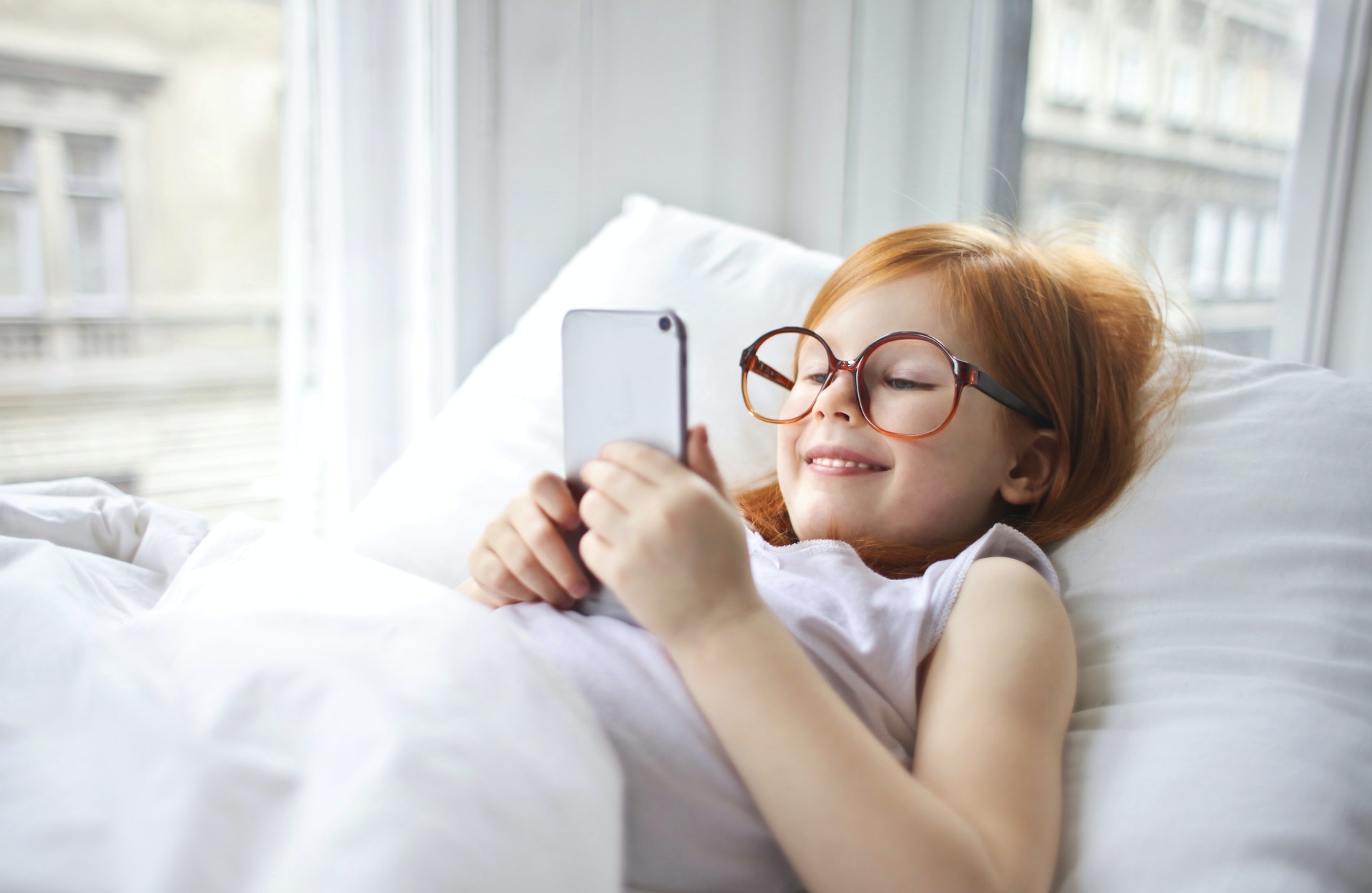 photo-of-smiling-young-girl-in-white-tank-top-lying-on-bed-3764565-2-.jpg