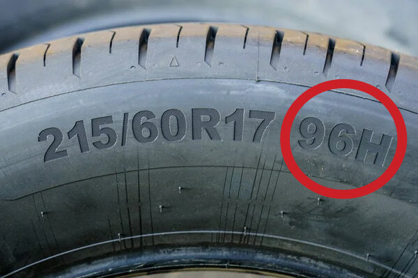 Closeup of a tire sidewall showing '96H' tire load index circled in red