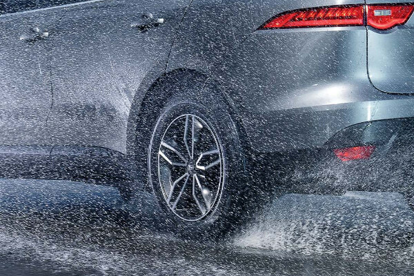 All-season tire on a vehicle driving through a rainy and wet road